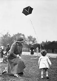 Grandmother with toddler girl (2-3) playing with kite