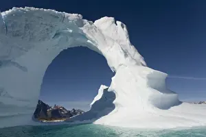 Paul Souders Photography Prints: Greenland, Frederiksdal, Arched iceberg frames mountain peaks on Pamiagdluk Island