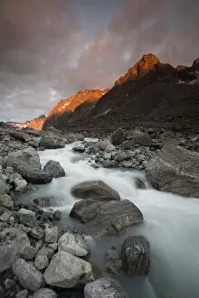 Stream Flowing Water Gallery: Greenland, Itilleq, setting sun lighting mountain peaks above mountain stream along Itilleq Fjord