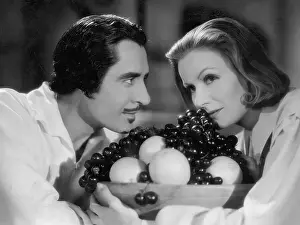 Prints of (Original Caption). Greta Garbo and John Gilbert exchange confidences over a bowl of fruit. Movie still from Queen Christina Timeless Elegance: The Iconic Greta Garbo Collection: Greta Garbo And John Gilbert With Fruit