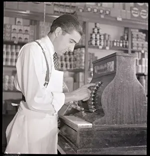 Groceries Prints: Grocer At Cash Register