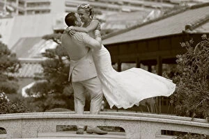 Images Dated 9th August 2014: Groom lifting the bride up in the air