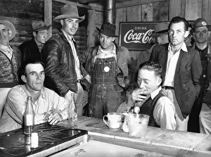 A Group Of Men Seated At A Bar