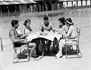 Group of people sitting poolside at hotel, eating dinner, Miami, Florida