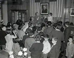 Guide of Children Pointing to Portrait on Wall