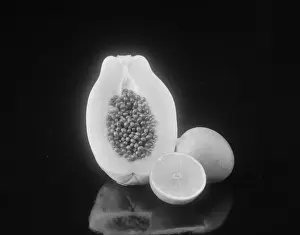 Papaya Prints: Half cut papaya and lemon on black background