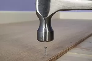 Hammering a ring-shank nail in to plywood on the floor