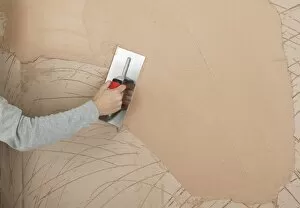 Horizontal Image Gallery: Hand applying plaster to a wall with a trowel