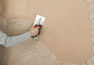 Working Prints: Hand applying plaster to a wall with a trowel