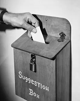 Retrofile Gallery: Hand dropping note in suggestion box