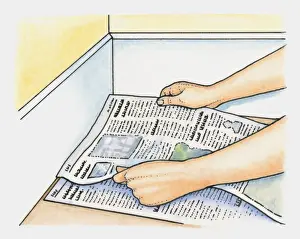 Carpet Prints: Hands placing layers of newspaper as alternative to underfelt on clean hard floor before laying carpet