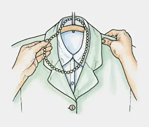 Hands placing necklace of beads over hanger holding jacket and blouse