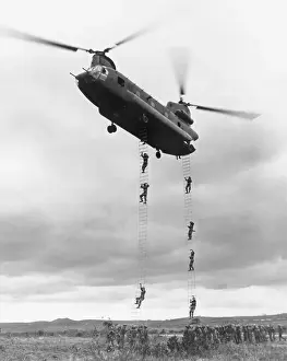 Helicopter With Men Climbing Down Ladder