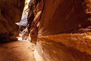High rock walls and a narrow path at the entrance to an ancient city