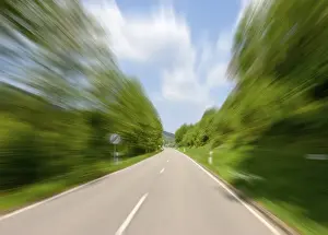 Motion Blur Prints: High speed motion, road with a sign showing the end of a speed limit of 60 km h