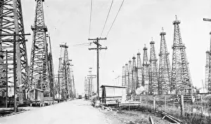 Derrick Prints: Highway Going Thru Rows Of Oil Drills