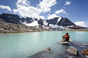 Images Dated 9th July 2011: Hiker taking a break at the lake below Mt Tschenglser Hochwand or Croda di Cengles