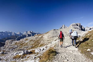 Hikers on the Buellelejoch Pass during the ascent to Paternkofel Mountain, looking towards Paternkofel Mountain