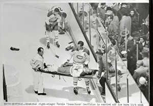 Prints of (Original Caption). Montreal right winger Bernie Boom-Boom Geoffrion, is carried off ice here with damaged ribs, as first casualty of the National Hockey league season Frozen Moments: A Journey Through Hockey History: Hockey Players in Action