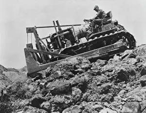 Prints of A Caterpillar Sixty Track-Type bulldozer working 800-feet above the Colorado River, one of six one-man roadbuilding machines used in the construction of the Hoover Dam A Timeless Collection of Hoover Dam Photography: Hoover Dam Construction