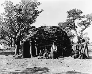 Prints of A family from the Hopi American Indian tribe poses outside of their hogan, Arizona, 1920s. The man sits with a traditional conga drum. (Photo by Frederic Lewis/Getty Images) Urban Echoes of America’s Golden Age: Hopi American Indian Hogan
