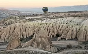 Images Dated 5th November 2014: Hot air balloon flying over rock landscape at Cappadocia Turkey