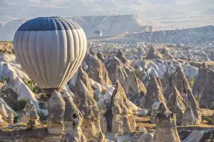 Hot air balloon flying over rock landscape at Cappadocia Turkey