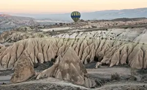 Central Anatolia Prints: Hot air balloon flying over rock landscape at Cappadocia Turkey