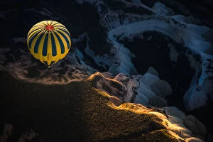 Hot air balloon over volcanic rock formation