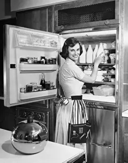 House wife removing milk from refrigerator