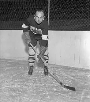 Prints of (Original Caption). Howie Morenz, center for the Chicago Black Hawks of the National Hockey League, and 1933's winners of the Stanley Cup, is shown in this photograph Frozen Moments: A Journey Through Hockey History: Howie Morenz Posing with Hockey Stick