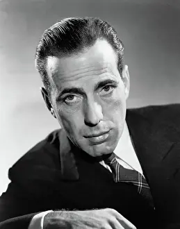 Prints of (Original Caption). A publicity portrait of actor Humphrey Bogart leaning forward and wearing a suit and tie in a studio setting. Ca. 1930-1957 The Essence of Cool: Humphrey Bogart