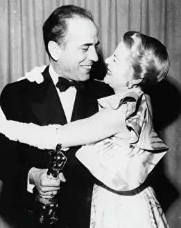 Prints of Actor Humphrey Bogart holding his Best Actor Oscar for the film The African Queen, with presenter Claire Trevor, at the 24th Academy Awards, Los Angeles, March 20th 1952 The Essence of Cool: Humphrey Bogart And Claire Trevor