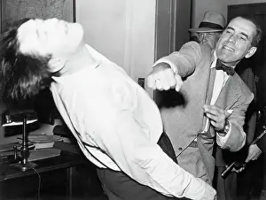 Prints of (Original Caption). Humphrey Bogart, the actor, punching a man and knocking him backward. This has the appearance of scene from a movie, but it is uncertain. Undated photograph The Essence of Cool: Humphrey Bogart Punching Another Actor