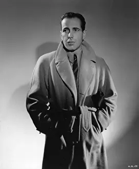 Prints of UNITED STATES - CIRCA 1940: Humphrey Bogart (1899 - 1957) dons a trench coat during a publicity shoot in Hollywood around 1940. (Photo by Transcendental Graphics/Getty Images) The Essence of Cool: Humphrey Bogart In A Trench Coat