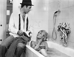 Prints of 1963: French actor Michel Piccoli sits on the edge of a tub while French actor Brigitte Bardot takes a bath in a still from director Jean-Luc Godard's film, Contempt ('Le Mepris') Iconic Movie Star Prints (1920s–1970s): Am I Disturbing You?