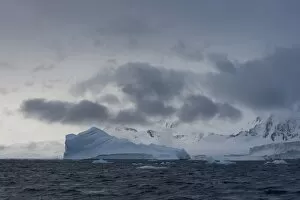 Images Dated 3rd February 2013: Iceberg in a fjord with mountain scenery and a cloudy sky, Gerlache Strait, Antarctic Peninsula