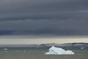Svalbard Islands Prints: Iceberg floating in Palanderbukta fjord during strong winds and storm clouds