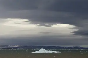 Iceberg floating in Palanderbukta fjord during strong winds and storm clouds, Nordaustlandet, Svalbard Archipelago, Svalbard and Jan Mayen, Norway