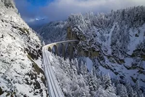 Iconic swiss red Bernina Express train in winter landscape and pristine snow. Swizerland, Europe