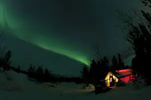 Illuminated, lit wall tent, cabin with swirling northern polar lights, Aurora Borealis, green, near Whitehorse, Yukon Territory, Canada