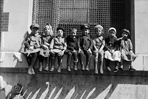 Immigrant Children Sitting on Window Ledge