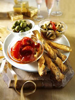 Italian Party buffet food with dried tomatoes, bread sticks or bread sticks, olives and marinated wild mushrooms