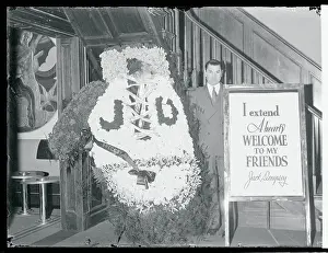Jack Dempsey Standing Next to a Large Wreath