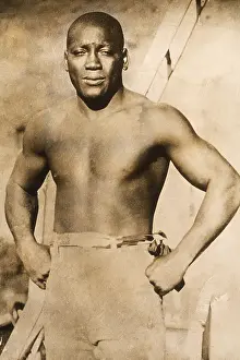 Prints of circa 1910: Portrait of boxer Jack Johnson (1878 - 1946), the first African-American to win the heavyweight crown, standing barechested with his hands on his hips In the Ring: The Art of Boxing: Jack Johnson