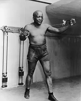 Prints of circa 1905: American heavyweight boxing champion Jack Johnson (1878 - 1946) stands and holds two handles as he works out with weights on pulleys. (Photo by American Stock/Getty Images) In the Ring: The Art of Boxing: Jack Johnson