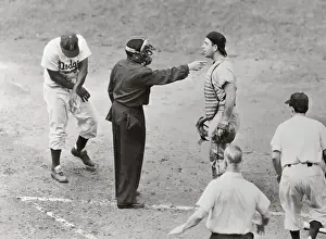 Jackie Robinson Examining Arm and Umpire Pointing at Catcher