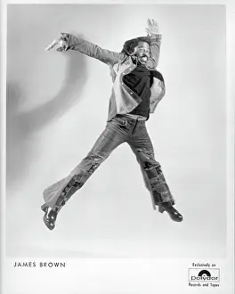 Prints of 1977: Godfather of soul James Brown poses for a Polydor Records publicity portrait jumping in the air with legs outstretched and sporting a mustache in circa 1977 Soul Power: A Visual Journey Through the Godfather of Soul’s Electrifying Legacy: James Brown Jumping Portrait