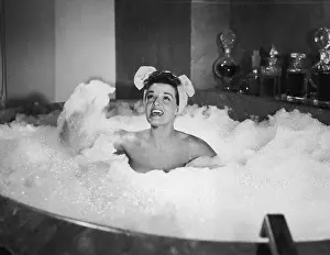 Prints of 1954: American actor Jane Russell, soaking in a bubble bath, sings toward the sky as she flings bubbles in a still from director Lloyd Bacon's film, The French Line' Hollywood's Sultry Siren – A Photographic Tribute: Jane Russell