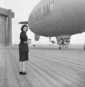 Prints of (Original Caption) The Sky's the Limit when Howard Hughes, industrialist, engineer and producer of motion pictures, decides to do a selling job Hollywood's Sultry Siren – A Photographic Tribute: Jane Russell by Promotional Blimp